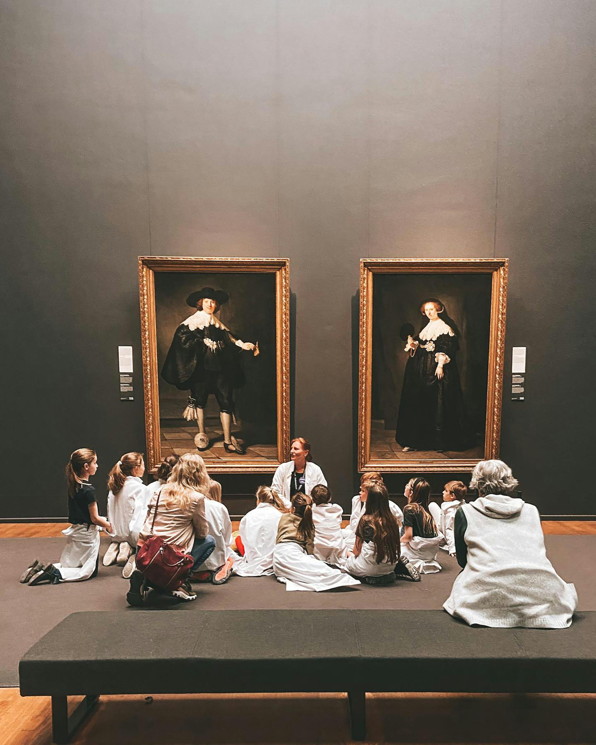 Children's educational group viewing Rembrandt paintings at an Amsterdam museum.